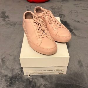 Pink Common Project sneakers with extra new laces.